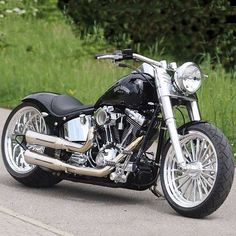 a black and chrome motorcycle parked on the side of a road next to some grass