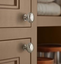 two knobs on the side of a cabinet with white towels in the back ground