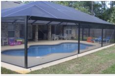 a backyard with a pool and covered patio area