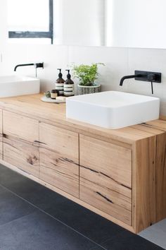 a bathroom with a sink, mirror and wooden cabinet in front of the counter top