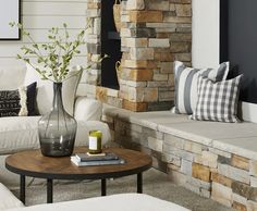 a living room filled with furniture and a fire place next to a stone fireplace mantel