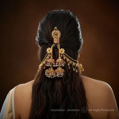 the back of a woman's head wearing gold jewelry