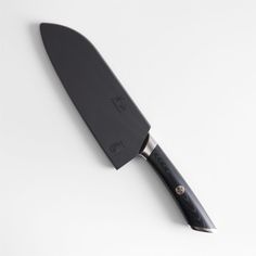 a large black knife sitting on top of a white table