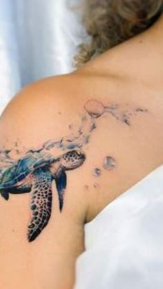 a woman with a tattoo on her shoulder that has a sea turtle in the water