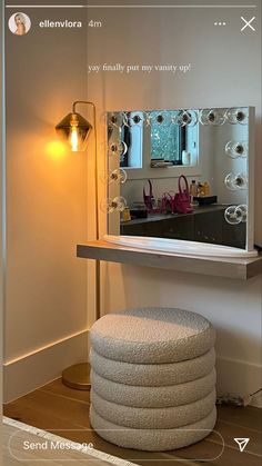 a white stool sitting in front of a mirror