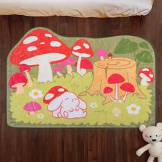 a teddy bear sitting next to a rug with mushrooms on it