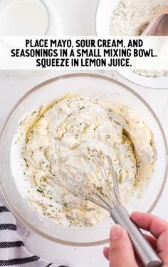 a bowl filled with cream and sauce next to a whisk in a glass bowl