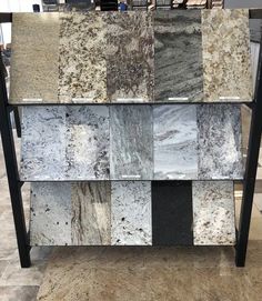 an assortment of marble tiles on display in a store or showroom with black metal legs