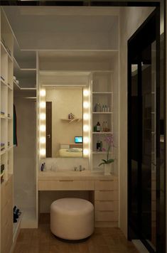 a white stool sitting in front of a bathroom vanity with lights on the mirror above it