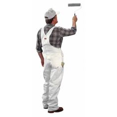 a man holding a paint roller in one hand and wearing overalls on the other