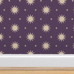 a purple wall with gold stars on it and a white door frame in front of it