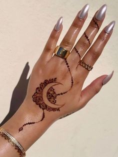 a woman's hand with hennap and rings on her left wrist, which is decorated with an intricate design