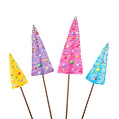 three colorful plastic trees on sticks with candy toppings