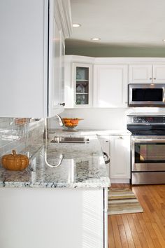 a kitchen with white cabinets and stainless steel appliances