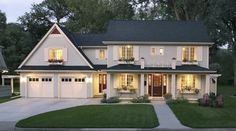 a large white house with two story windows and lights on it's front porch