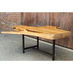 a wooden table with metal legs and a slab of wood on it's side