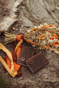 a couple of tags sitting on top of a rock next to some flowers and grass