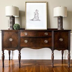 two lamps sitting on top of a wooden dresser