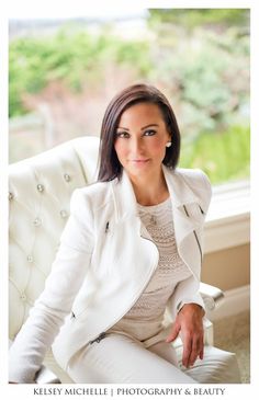 a woman sitting on top of a white chair in front of a window with the words kelsey michele photography & beauty