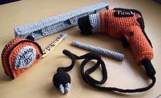 an orange and black knitted object laying on top of a table next to a pair of scissors