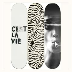 three skateboards with different designs on them and the words cest la vie in black and white