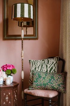 a chair and table in a room with pink walls