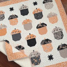 an orange and white quilt with black pumpkins on the front, stars in the back