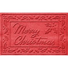 a red door mat with merry christmas written on the front and bottom, in an ornate design