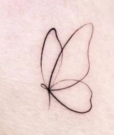 a small butterfly tattoo on the back of a woman's stomach, with black ink