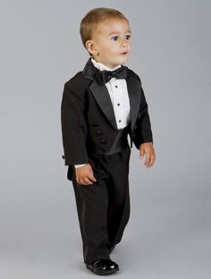 a young boy in a tuxedo and bow tie