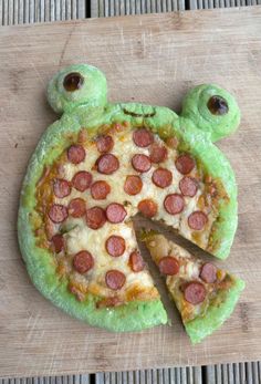 a pizza shaped like a frog with one slice missing