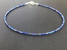 A minimalist necklace made with rich blue beads of genuine lapis lazuli. These AAA quality stones measure 2mm in diameter, and they are round with multifaceted cuts that give them a little extra shimmer in the light. There is a small silver bead at each end, and this connects with a sterling silver lobster claw clasp in the back. Available in a variety of lengths, and comes packaged in a small gift box for you. Ships in 1 business day, via USPS ground advantage. Sapphire Lapis Lazuli Jewelry With Faceted Details, Blue Tiny Beads Round Jewelry, Blue Round Jewelry With Tiny Beads, Blue Faceted Lapis Lazuli Jewelry, Faceted Blue Lapis Lazuli Jewelry, Blue Lapis Lazuli Jewelry With Faceted Beads, Blue Minimalist Jewelry With Faceted Beads, Rabbit Jewelry, Blue Stone Necklace