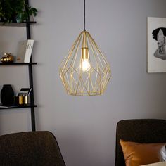 a light that is hanging from the ceiling in a room with a chair and table