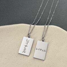 This listing is for a personalized engraved Japanese name tag necklace in stainless steel. Stainless steel jewelry is strong and almost never tarnish or corrode.  The sample necklace on the left is vertically engraved with the name Rachel in Japanese in font style #5 and the necklace on the right is horizontally engraved with the name Rachel in Japanese in font style #1. If there are many characters, they will be engraved in two or three lines. Please check the font options in the pictures. The Name Tag Necklace, Japanese Necklace, Roman Letters, Kanji Characters, Japan Gifts, Japanese Jewelry, Japanese Characters, Japanese Names, Font Style