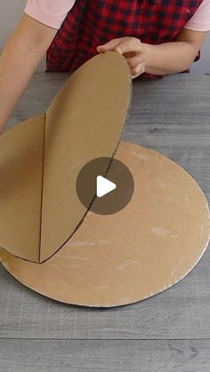 a person cutting out a cardboard heart with scissors