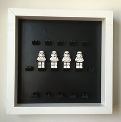 legos are arranged in a shadow box to look like stormtroopers on display