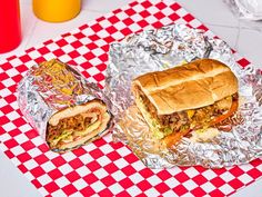 two sandwiches sitting on top of tin foil