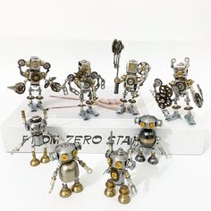 an assortment of metal robot figurines sitting on top of a white box