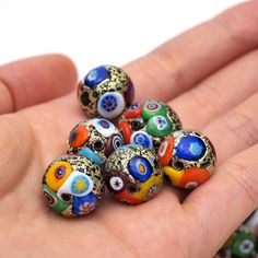 a hand holding several colorful beads in it's palm