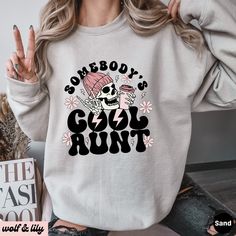 Get ready to be OBSESSED with your new 'Somebody's Cool Aunt' sweatshirt. It's the cutest and most trendy way to emit all those important Auntie vibes! This is the perfect Aunt sweatshirt! Great as an Auntie gift! * Q U I C K * F A C T S * ✺ 50/50 cotton polyester blend - so soft it feels like a cloud on your skin! ✺ Machine wash cold, inside out. Tumble dry low or hang to dry. Do not bleach, iron or dry clean. * S I Z I N G * ✺ Models are wearing XL for the oversized look ✺ Sizing is unisex so runs like men's, though not overly large ✺ Most women find their typical size works best for a more fitted look, since they are meant to fit a touch loose ✺ For the trendy oversized look, we recommend sizing up 1-2 sizes from your normal size ✺ Size guide and fit: See photos * P R O D U C T I O N * Winter Slogan Sweatshirt With Long Sleeves, Cool Crew Neck Tops For Winter, Long Sleeve Slogan Sweater For Winter, Cool Cotton Winter Tops, Cool Cotton Tops For Winter, Long Sleeve Winter Sweater With Slogan, Trendy Winter Tops With Comfortable Fit, Trendy Comfortable Fit Tops For Winter, Trendy Comfortable Winter Tops