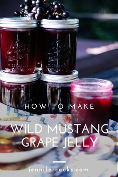 three jars filled with wild mustang grape jelly sitting on top of a table next to a plate