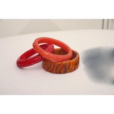 This is part of Chairish’s Costume Jewelry assortment.  The set of 3 art deco vintage authentic carved bangle bakelite bracelets are in the hues of red, amber orange and caramel. They are all hand carved and the orange caramel one is a thicker cuff with small swirls of black. The caramel on is 1.25" H x 3" W and the interior of that one is approx. 2.5" W. The other two are .5" H x 3.5" W and the other of those are 2.5" W. They will fit over a small medium wrist or medium wrist but not an extra w Red Carved Vintage Jewelry, Carved Red Vintage Jewelry, Red Retro Bangle Jewelry, Vintage Carved Orange Jewelry, Handmade Bakelite Bangle Bracelet, Orange Carved Vintage Jewelry, Vintage Orange Carved Jewelry, Handmade Round Bakelite Jewelry, Vintage Orange Bangle Bracelets