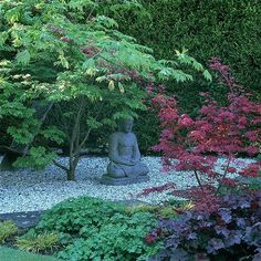 a buddha statue sitting in the middle of a garden