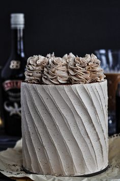 a white cake with frosting and ruffles sitting on top of a table