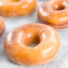 glazed doughnuts sitting on top of a baking sheet