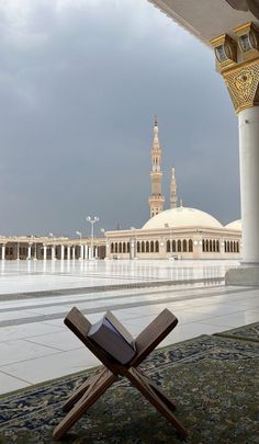 an open book sitting on top of a wooden chair in front of a large building