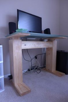 a computer desk with a monitor and keyboard on it in a room that has carpeted flooring