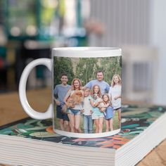 a family photo on a coffee mug sitting on top of a book