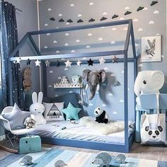 a child's bedroom decorated in blue and white with animals on the walls, bedding and rugs