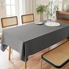 a dining room table covered with a gray tablecloth